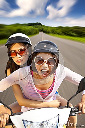 Two girls riding scooter Stock Photo