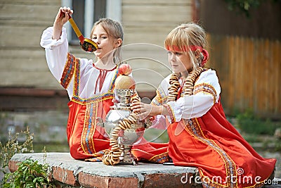 Two girls in Russian national costumes with samovar Stock Photo