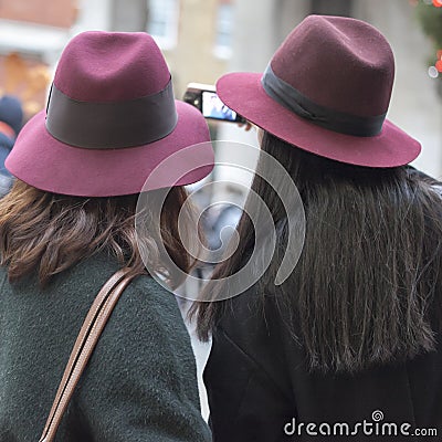 Two girls in the same burgundy hats make selfie Editorial Stock Photo