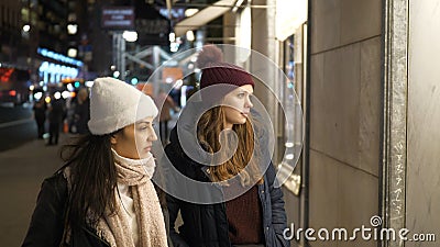 Two girls on a shopping trip in New York walk along shop windows Stock Photo
