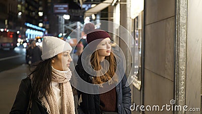 Two girls on a shopping trip in New York walk along shop windows Stock Photo