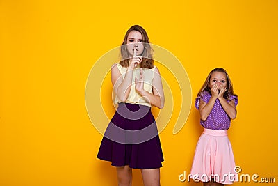 Two girls shut mouth finger silence Stock Photo