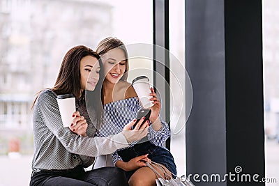 Two girls sit and drink coffee in a shopping center Stock Photo