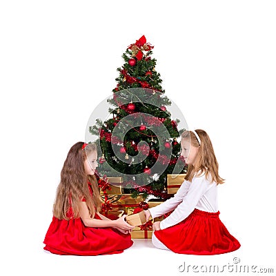 Two girls sit near Christmas tree. Stock Photo