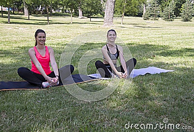 Two girls stretch their legs in the park.Novi Sad.Liman park. Stock Photo