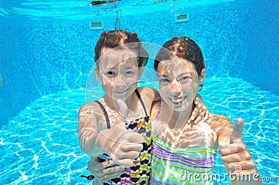 Two girls underwater in swimming pool Stock Photo