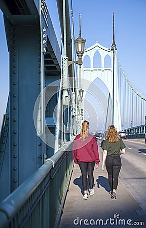 Two girls walk along the sidewalk on St Jones Bridge Editorial Stock Photo