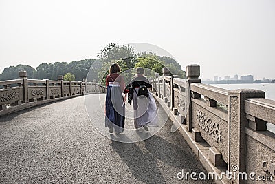Two girls wearing ancient costumes walk in Harmony Lake Park Editorial Stock Photo