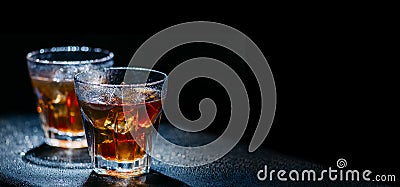 Two glass of cold alcohol cocktail drink on black background with copyspace. Whiskey with ice and cola on bar table Stock Photo