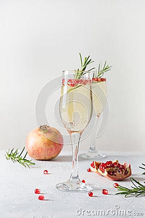 Pomegranate Christmas cocktail with rosemary, sparkling wine on white table. Xmas Holiday drink Stock Photo
