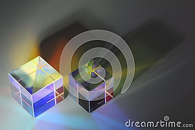 Two glass prism cubes close-up refract light and cast colored shadows Stock Photo