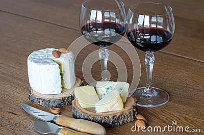 Two glass of red wine with few pieces of cheese at wooden background. side view. Stock Photo