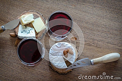 Two glass of red wine with few pieces of cheese at wooden background. top view Stock Photo