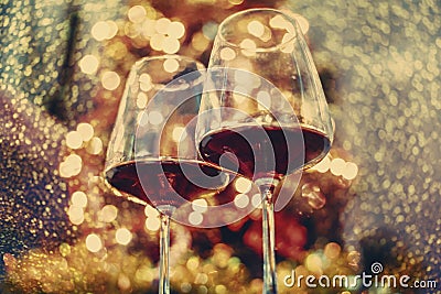 Two glass of red wine in front of christmas tree lights bokeh. New year eve and xmas celebration party Stock Photo