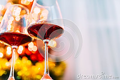 Two glass of red wine in front of christmas tree lights bokeh. New year eve and xmas celebration party Stock Photo