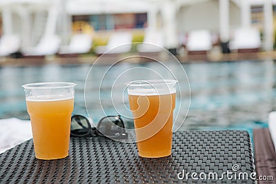 Two glasses beer sunglasses table pool Stock Photo