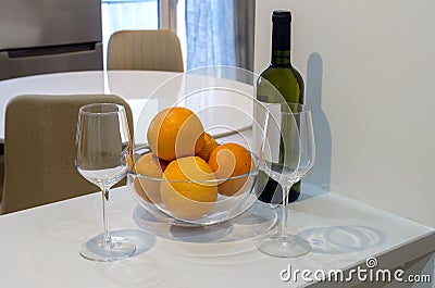 Two glasses, a bottle of white wine and a bowl of oranges close-up Stock Photo