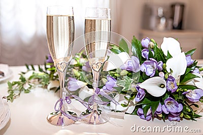 Two glasses of champagne and a bouquet of lilac freesias and white callas. Stock Photo