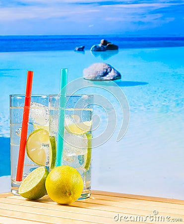 Two glasses of cocktail with lime slice on blur beach Stock Photo