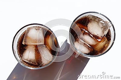 Two glasses of cola with ice cubes on white table. Top view, copy space. Hard light, shadow. Refreshing summer drink Stock Photo