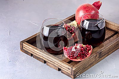 Two Glasses of Fresh Tasty Pomergranate Juice on Gray Background Diet Healthy Drink Detox Ripe Pomegranate Wooden Tray Horizontal Stock Photo