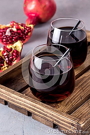 Two Glasses of Fresh Tasty Pomergranate Juice on Gray Background Diet Healthy Drink Detox Ripe Pomegranate Wooden Tray Vertical Stock Photo