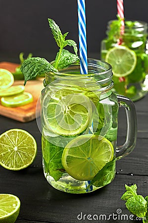 Two glasses of lemonade or mojito cocktail with fresh limes and mint. Stock Photo