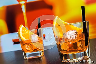 Two glasses of spritz aperitif aperol cocktail with orange slices and ice cubes on bar table, disco atmosphere background Stock Photo