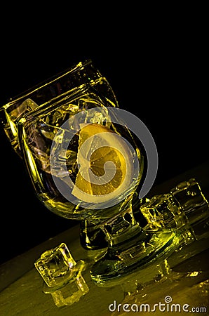 Two glasses of water, lemon and ice in yellow color Stock Photo