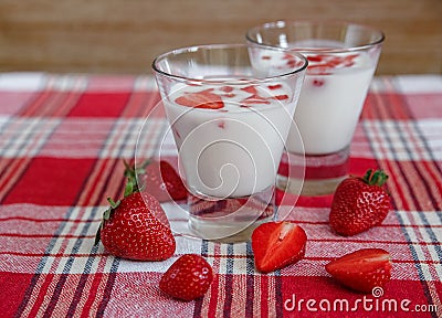 Two Glasses of Yogurt,Red Fresh Strawberries on the Check Tablecloth.Breakfast Organic Healthy Tasty Food.Cooking Vitamins Stock Photo