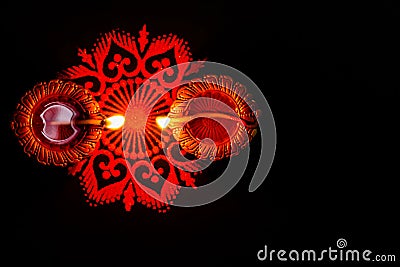 Two glowing terracotta lamps and rangoli against dark background. diwali concpet Stock Photo