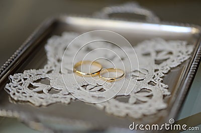 Two gold rings on a silver tray Stock Photo