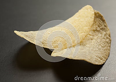 Two golden potato chips in heart shape on the black, selective f Stock Photo