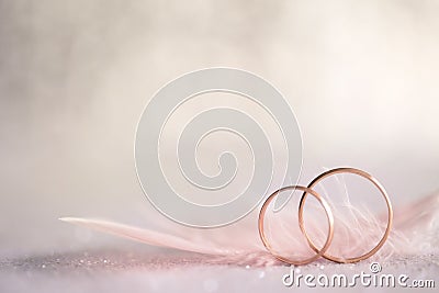 Two Golden Wedding Rings and Feather - gentle background Stock Photo