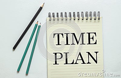 Two green one black pencil with text Time Plan in the notebook on the white background Stock Photo