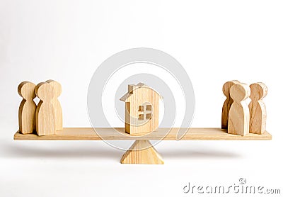 Two groups of people on the scales are suing the house. Conflict of interests and claims regarding the ownership of house. Illegal Stock Photo