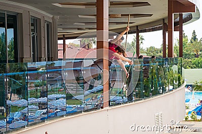 Two guys, a cleaning company employee, wash windows and glass. They are dressed in red uniforms Editorial Stock Photo