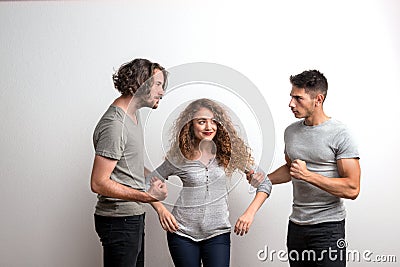 Two guys fighting over a girl, a studio shot. Stock Photo