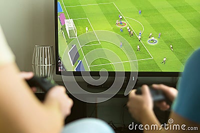 Two guys playing imaginary multiplayer soccer or football game Stock Photo