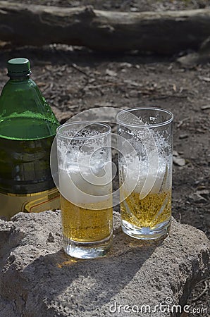 Two half-empty glass glasses with beer on top of the stone outside Stock Photo