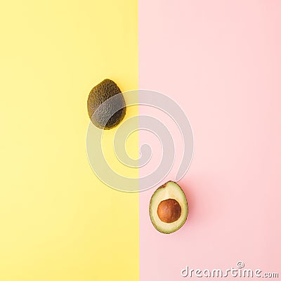 Two halves of avocado on a pastel yellow and pink background Stock Photo