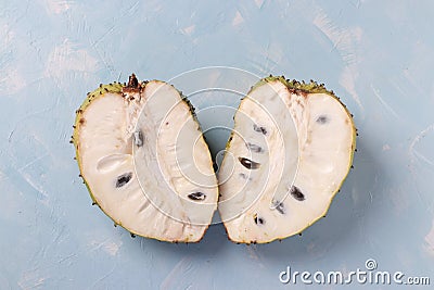 Two halves of ripe soursop on light blue background, top view Stock Photo