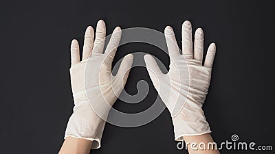 Two hand wear white latex gloves on black background Stock Photo