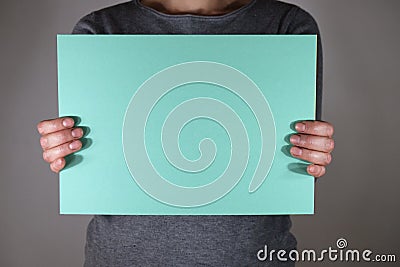 Two hands holding blue paper sheet Stock Photo
