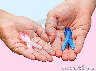 Two hands holding two Pink and Blue ribbons for the Pink October and Blue November campaigns to support life and raise awareness Stock Photo