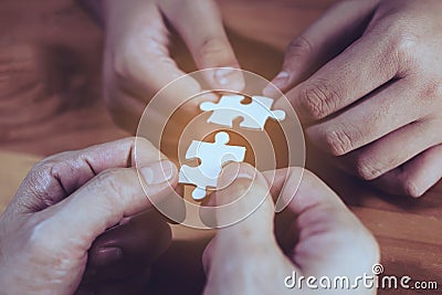 Two hands joining two jigsaws Stock Photo