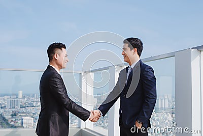 Two handsome businessmen greeting each other in the street Stock Photo