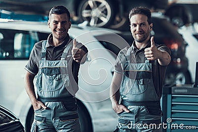 Two Handsome Happy Auto Mecanics Keeping Thumbs up Stock Photo