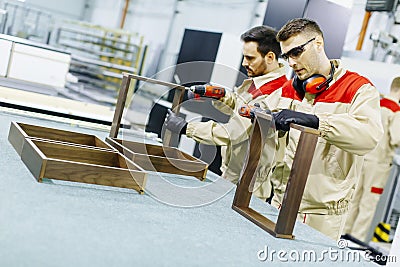 Two handsome young men working in furniture factory Stock Photo