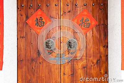 Two Handwriting Chinese blessing Fu on the traditional chinese wooden door with brass handle. Stock Photo